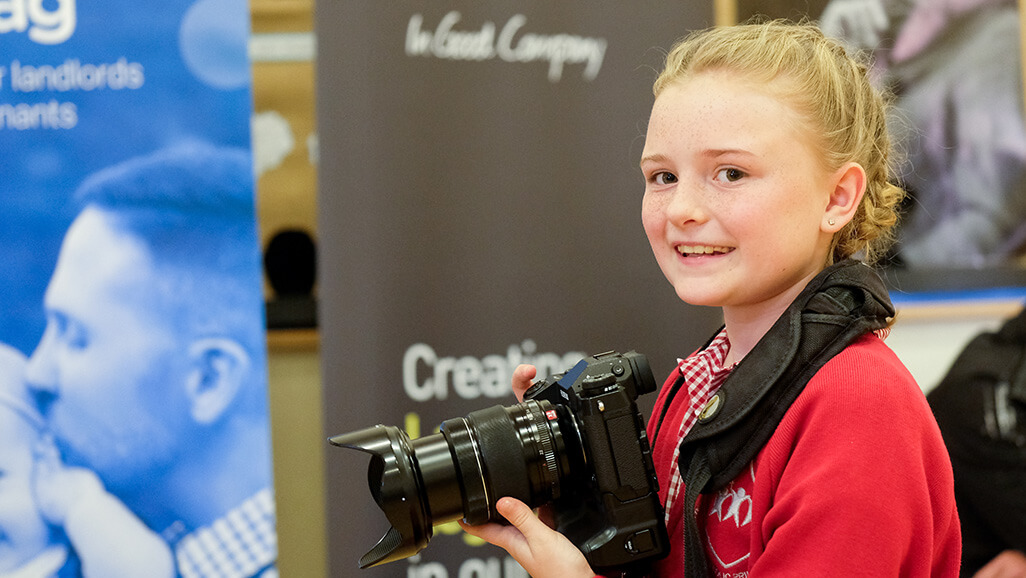 photo of a children from the Raising Aspirations programme taking photos of the Career Carousel event